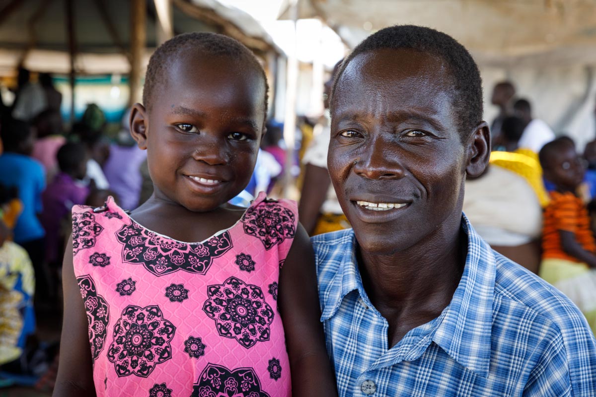 Uganda man holding young girl